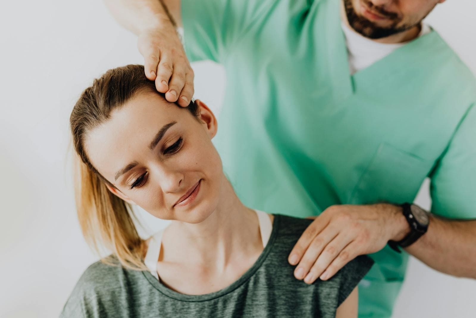 Profissional realizando atendimento manual na coluna de uma paciente em maca clínica
