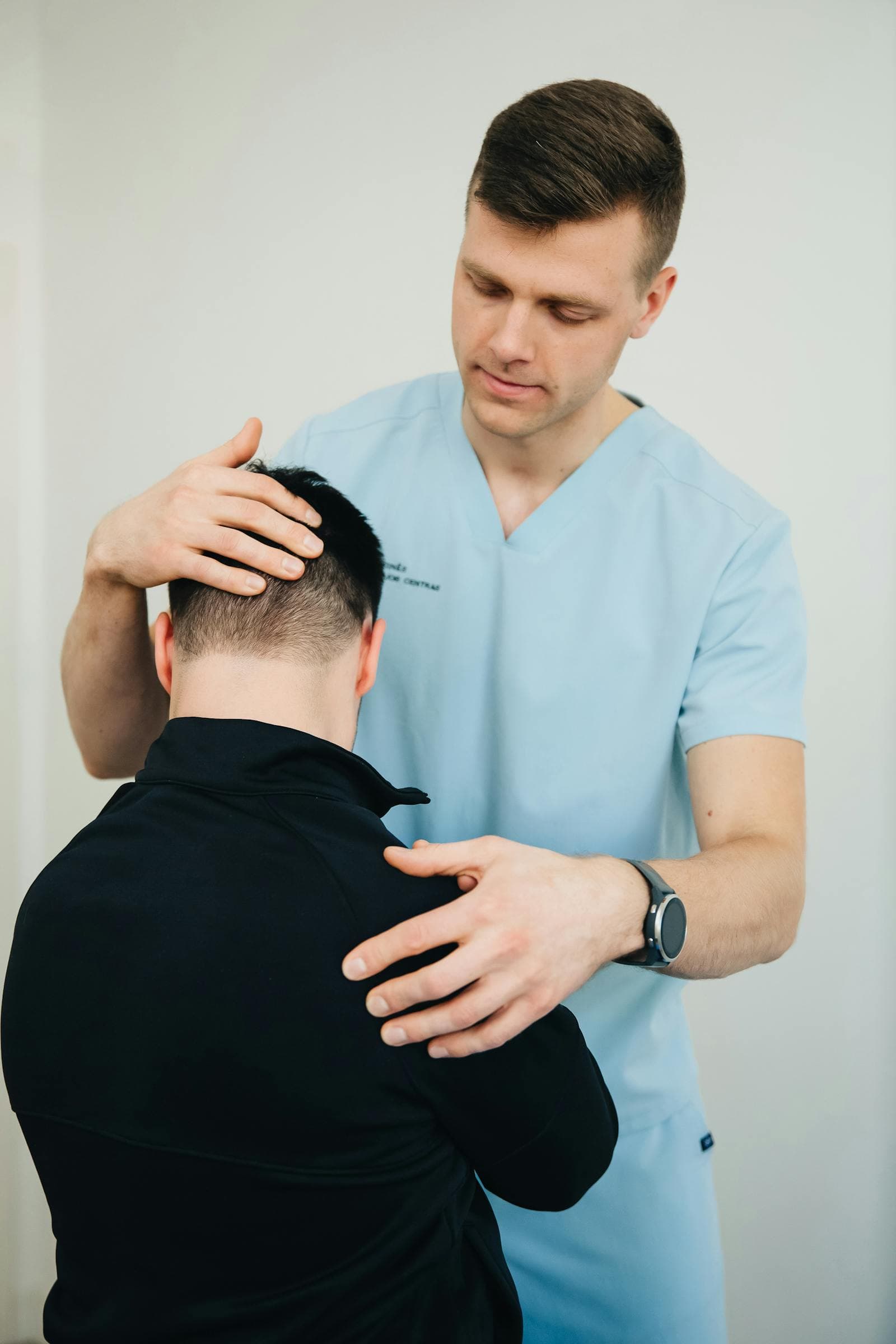 Profissional avaliando a mobilidade da coluna cervical de um paciente em ambiente clínico